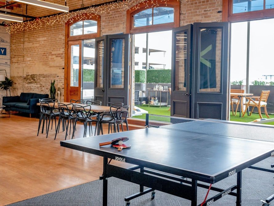 Table tennis table inside a bare-brick room with lots of light